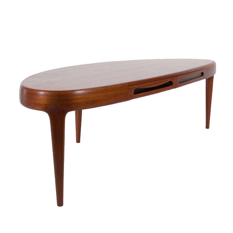 Teak oblong coffee table with two drawers on three tapered legs.
Made by Trensum.