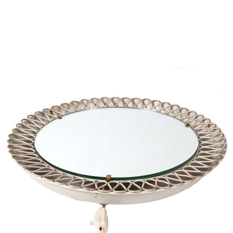 White painted metal wall mirror with swirling decorative edge; two lights to recessed back.