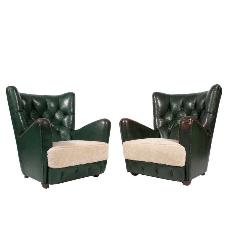 High back leather easy chairs with button back and base, sheepskin seats and original green leather.  On beechwood feet. Sold as a pair only.