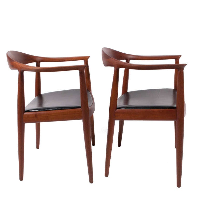 Pair of Classic chairs, designed in 1949, solid teak frame with black leather seats; imported by Knoll Associates. Retains Knoll label and manufacturer's burn mark. Made by Johannes Hansen.