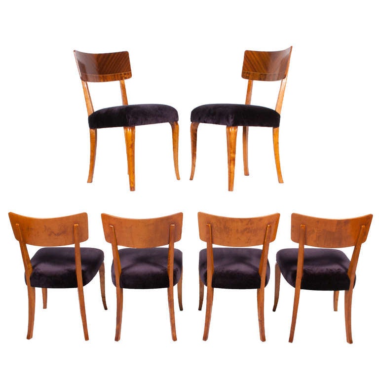 Six armless chairs, with broad back made of mahogany and inlaid designs of various fruitwood.  Frame and legs of solid flame birch. Reupholstered in mohair.
Made by Mjolby Intarsia Sweden.
