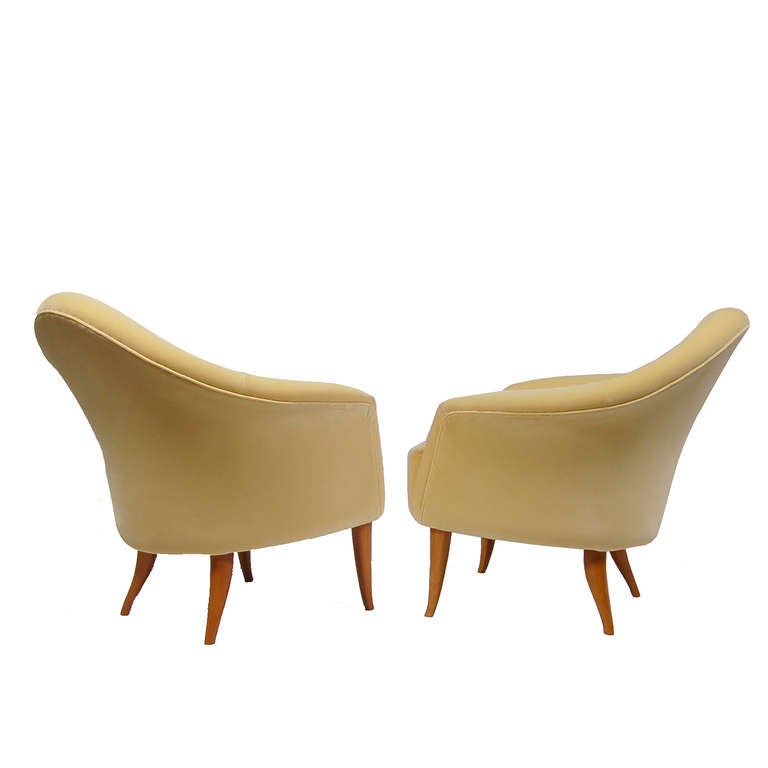 Sweet pair of easy chairs with curved arms and back, button tufted backrest and curved solid birch legs. Made by Nordiska Kompaniet.
