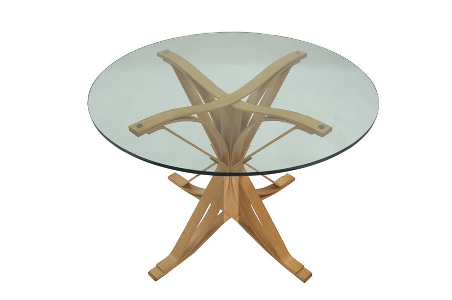 Curved hard white maple veneer plywood forms the base of this cafe table. Laminated to 8 ply thickness with solid maple center column. Clear glass round top with polished edge. Signed and dated (1995) to bottom of table. Made by Knoll Int'l. Set of