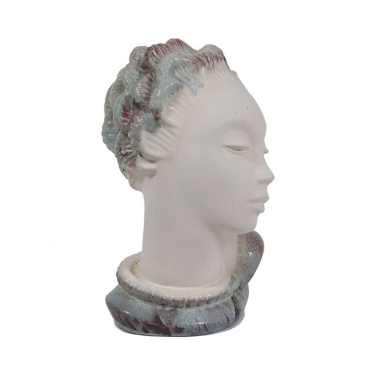 Bust of a woman with white matte glazed face and neck and multicolored 