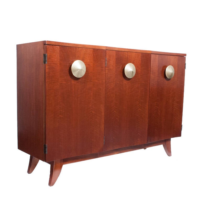 No. 4116, dining utility chest, from the Paldao Living-Dining Group, three concave doors open to reveal shelves, cork lined and felt lined drawers. 
Sits on base with curved legs. Large door pulls in brass.
Made by Herman Miller. Retains label in