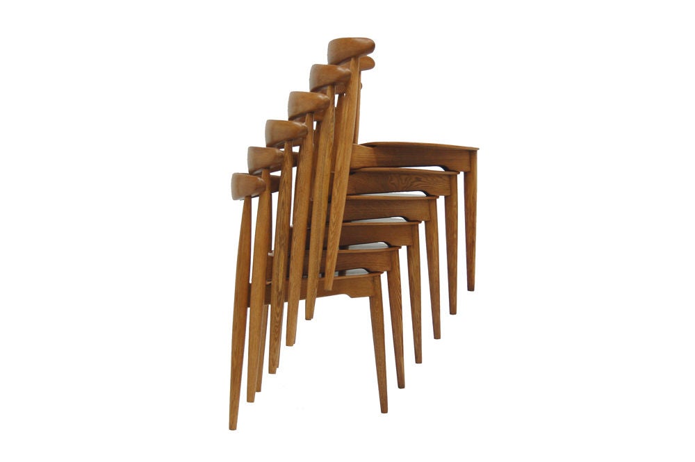 Six three legged stacking chairs with solid oak frame and teak triangular seat. Made by Fritz Hansen.