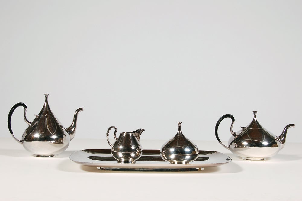 Five piece coffee set, silver plated; coffee and tea pot, sugar bowl, creamer and tray.
All marked with model numbers, design name and manufacturer's mark.  Black rattan wrapped handles. Made by Reed and Barton.