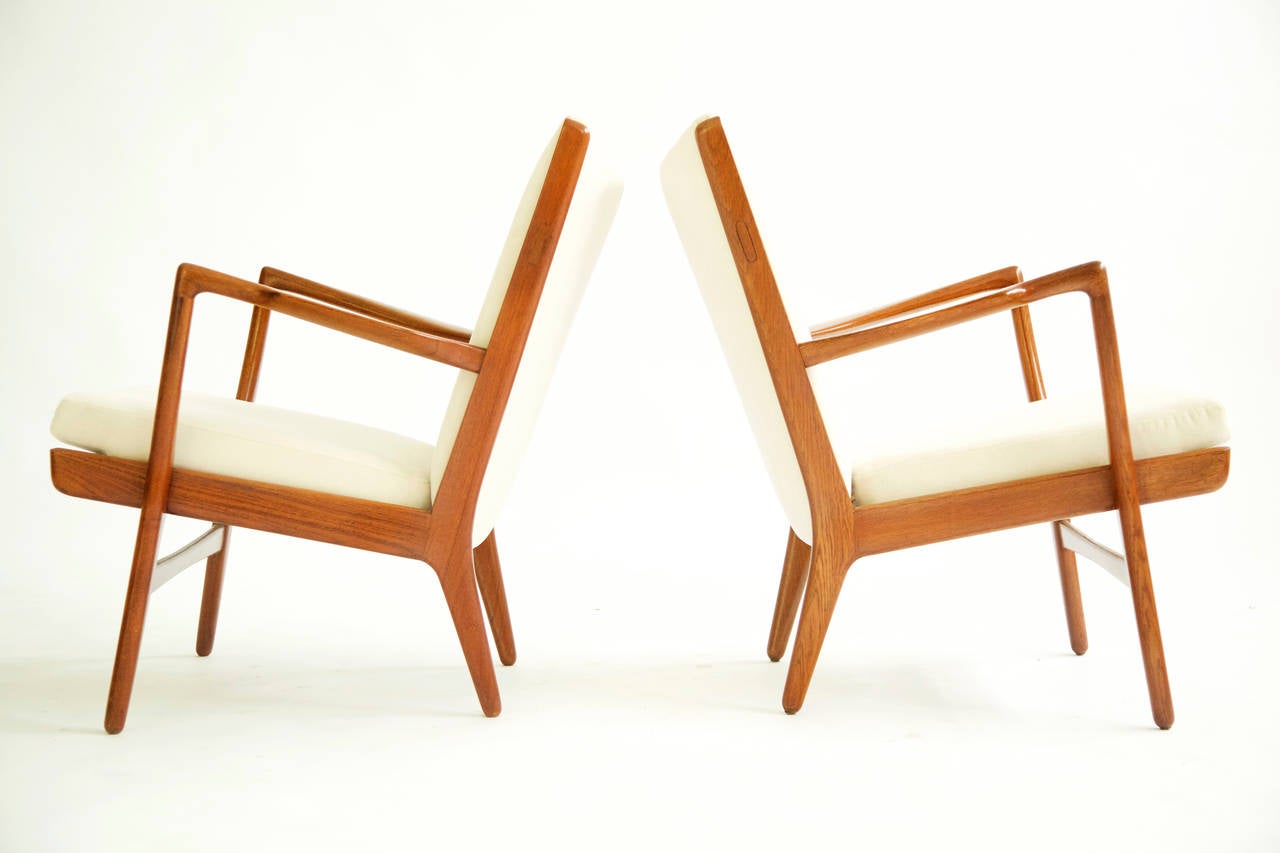 Wegner for AP Stolen, pair of teakwood lounge chairs, with sculpted arms and splayed legs, reupholstered with cotton velvet.
Stamped A.P. Stolen.