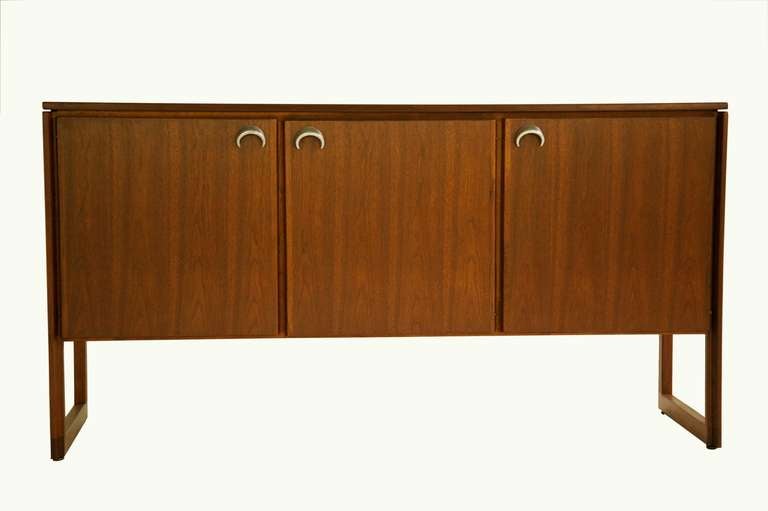 Risom for Risom Inc. three-drawer sled base cabinet. Oil finish walnut with aluminum eclipse pulls.
