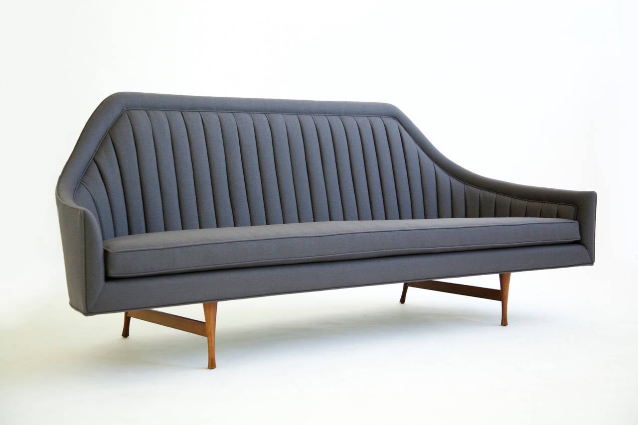 McCobb for Widdicomb symmetrical line channel back sofa.
Reupholstered with grey wool fabric.
Solid turned sculpted walnut legs.
Outside arm height 21