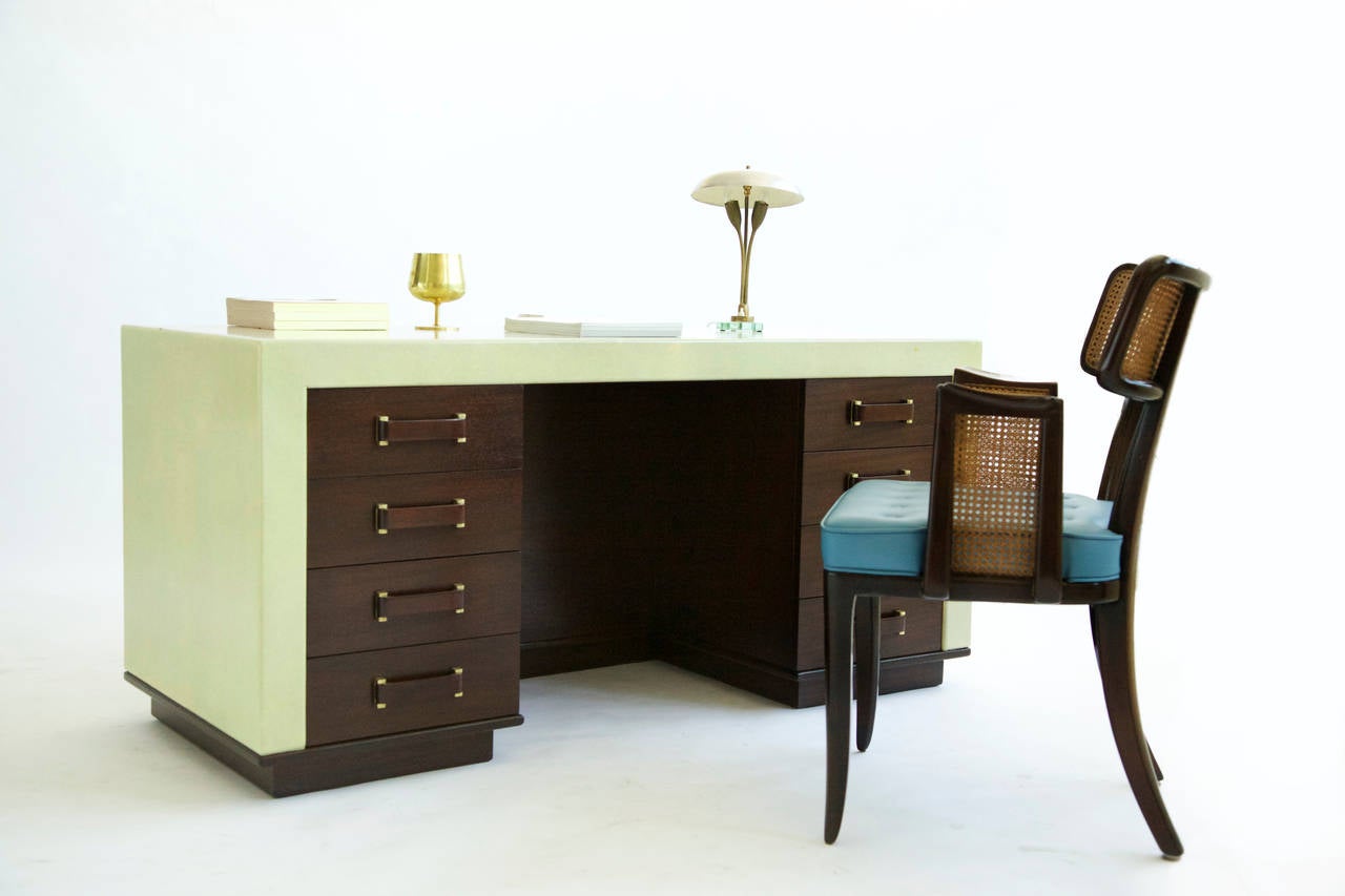 Frankl for Johnson furniture, parchment colored cork wrapped desk, Features eight drawers, mahogany pulls with brass accents, main structure on a plinth base, with cutout display box in front.
[Signed Paul Frankl for Johnson Furniture Company].