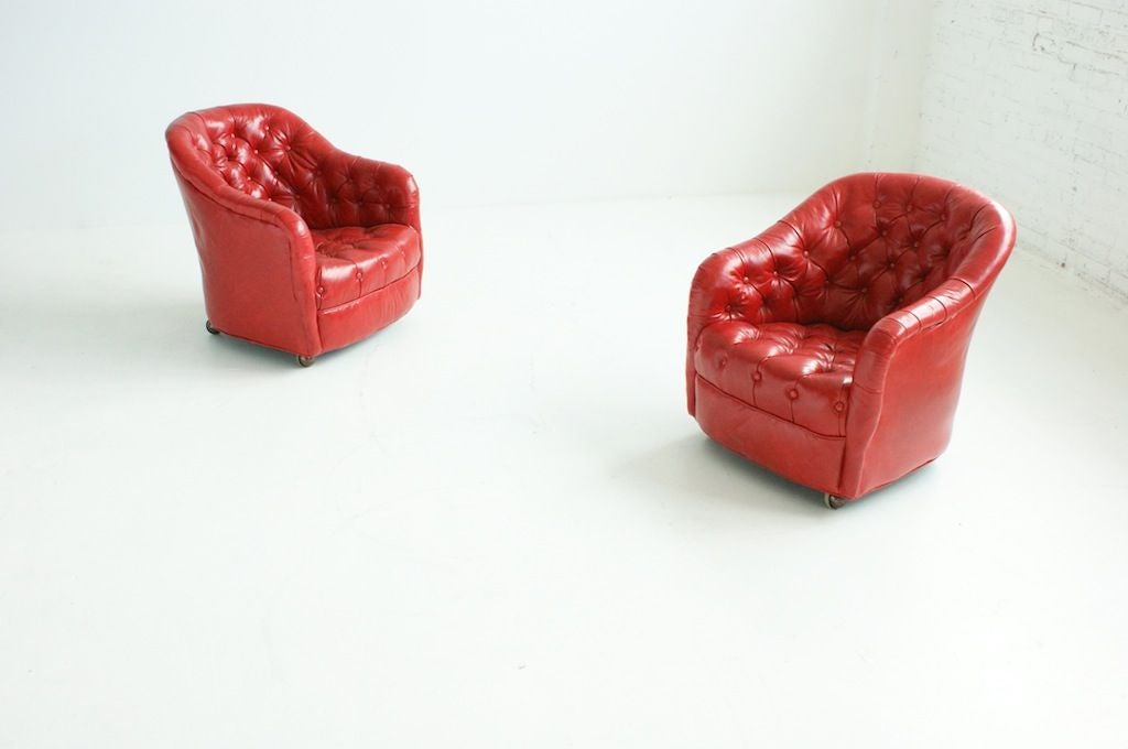 Pair of tufted lounge chairs on bronze casters.