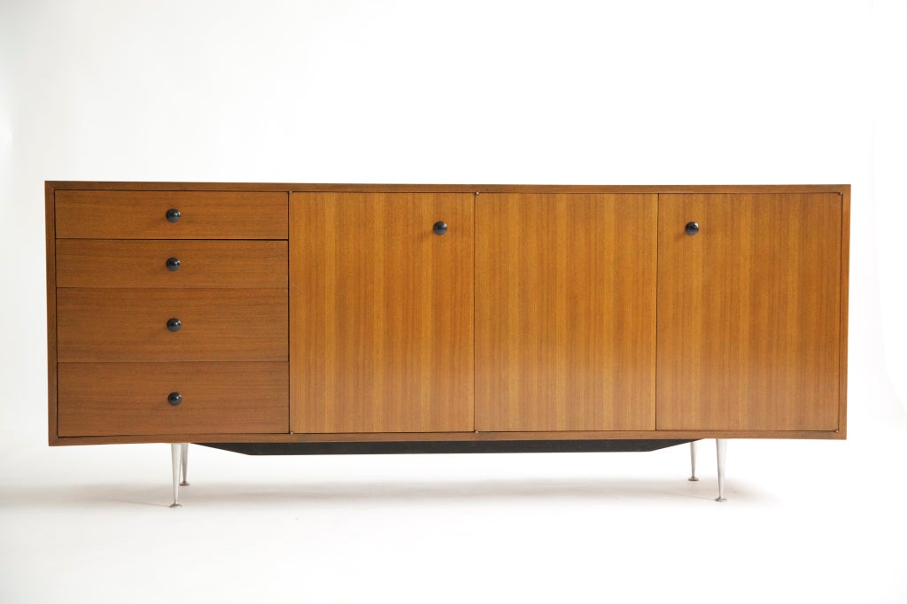 Nelson for Herman Miller, Thin Edge Credenza
Ribbon teak veneer, Aluminum tapered legs.

Cabinet features four drawers, one door concealing a single drawer and two doors concealing two adjustable shelves. Pullout serving shelf Signed with applied