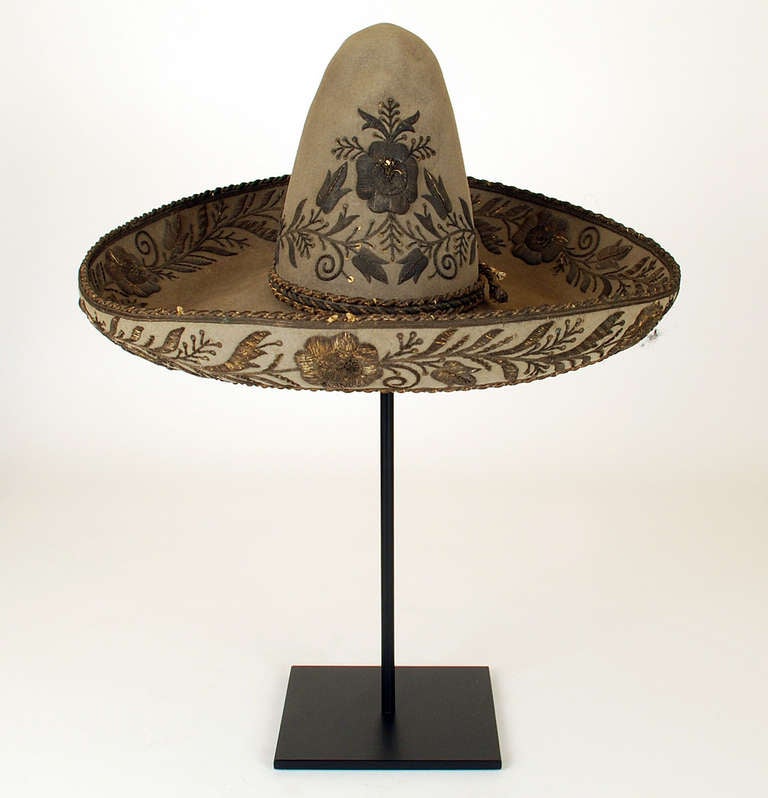 An exceptionally fine and rare late 19th century Mexican sombrero with 10.5 inch crown and 7 inch brim. Adorned all over in silver threaded vine pattern with heavy silver brocades. Leather sweatband is maker marked with eagle stamp. Displayed on a