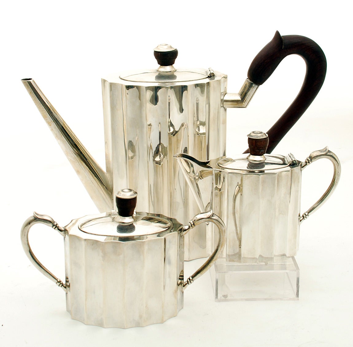 A fine and rare Mexican Art Deco coffee pot, cream and sugar service in sterling silver, circa 1930s-1940s. Each piece in heavy, high quality sterling silver with ribbings, hinged lid and rosewood knobs. The coffee pot with beautiful handcrafted
