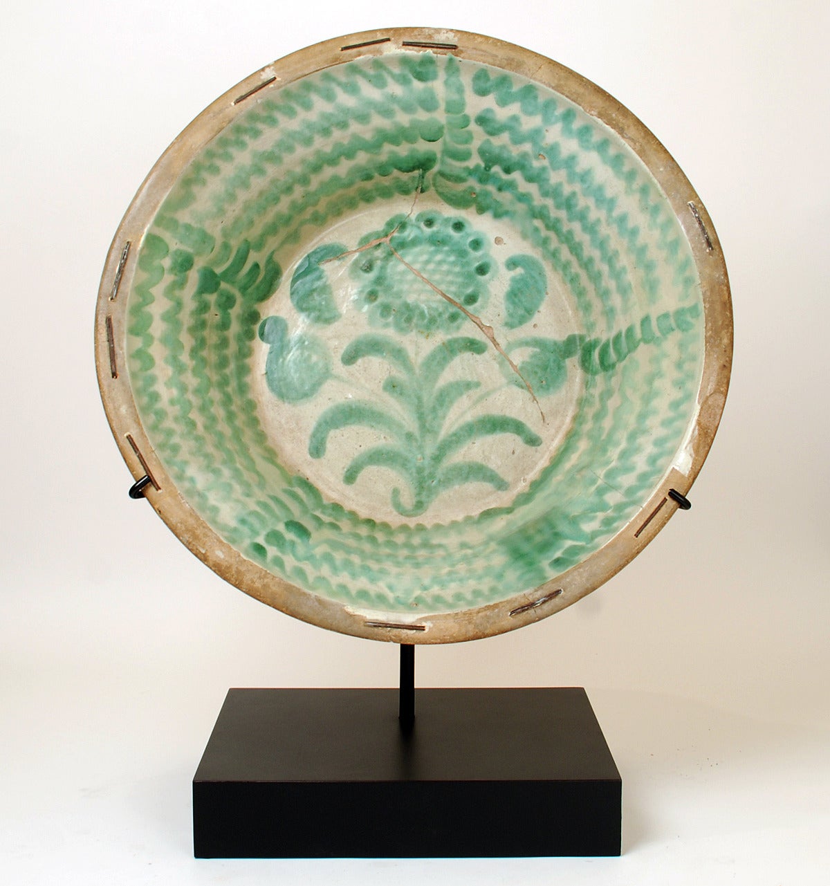 A large and impressive mid-19th century Spanish stoneware 'lebrillo' with beautiful 'morisco' green glaze over a milk white slip. This lebrillo features a large sunflower motif surrounded by whimsical foliate motifs Granada, circa 1860. Verso with