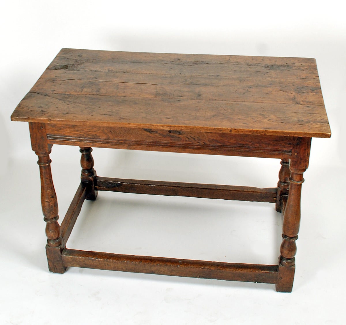 A handsome early 18th century William and Mary period tavern table with turned legs connected by a stretcher base. Beautiful color with lustrous surface patina. Circa 1700 - 1725.

Please note: the talavera pottery is shown for scale only and is