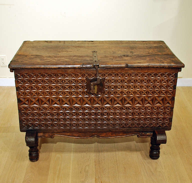 A fine 18th century Spanish colonial six panel chest in the Mudejar style, with multiple rows of deeply carved geometric patterns. Original iron hinges, hasp and lock-plate, together with the original wooden base. Circa 1750. 

Dimensions: 41