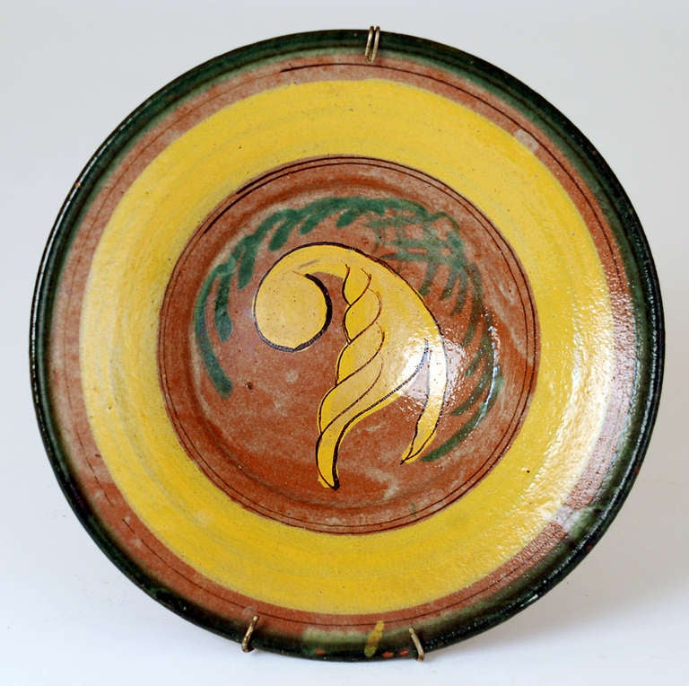 A very fine and rare late 19th century 'Montiel' plate from the 'Montiel Family Studio' in Antigua Guatemala.  A conch shell surrounded by foliage and yellow ring borders. See Marion Oettinger's 'Folk Art of Spain and the Americas' for a similar