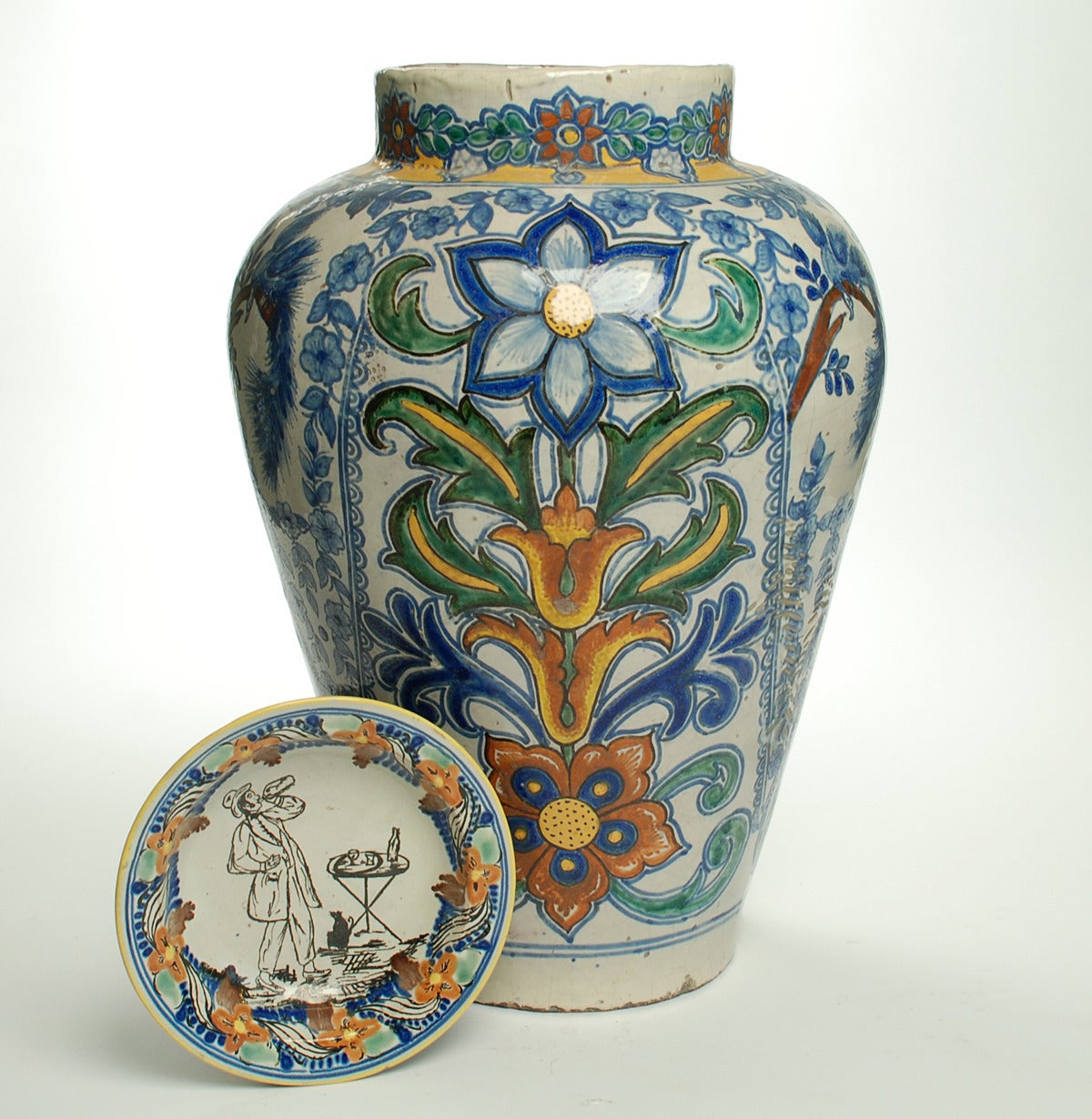 This large late 19th century talavera Poblana Jarron is decorated all over in deep shades of pale blue, green, yellow and red with colorful foliate patterns separated by ring borders and geometric motifs. The smaller talavera plate is shown for