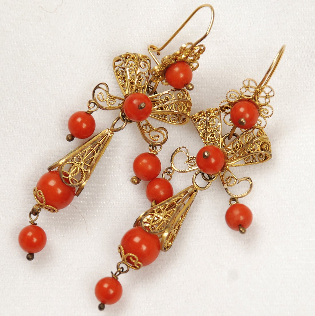 A pair of good antique Mexican earrings in 12-karat to 14-karat gold with skillfully crafted gold wire, filigree and beautiful coral beads, Oaxaca, circa 1930s-1940s.

Dimensions: Hang 2.25 inches.

Condition is excellent.