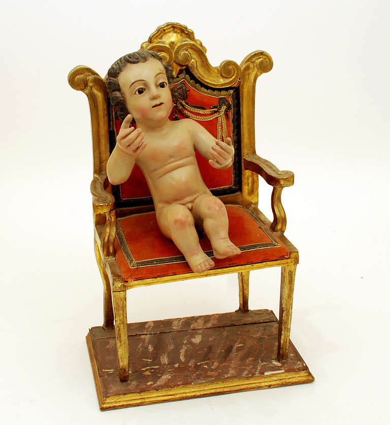 A charming 19th century Santo Nino de Jesus. Hand carved and polychrome painted wood with inset glass eyes. Gilt wood chair with brocade work and metallic threading. Circa 1850.

Dimensions: measures 20.5 inches high. 

Condition is excellent.