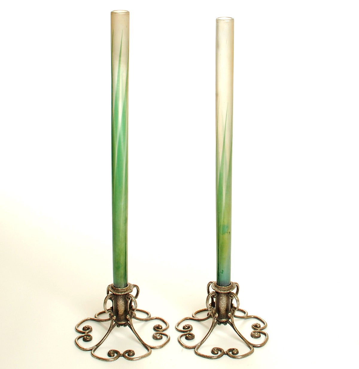 A pair of exceedingly fine and rare early 20th century Tiffany vases with original 'favrile' art glass stems supported by original art nouveau bases. Favrile glass is a type of iridescent glass that was designed and patented by Louis Comfort