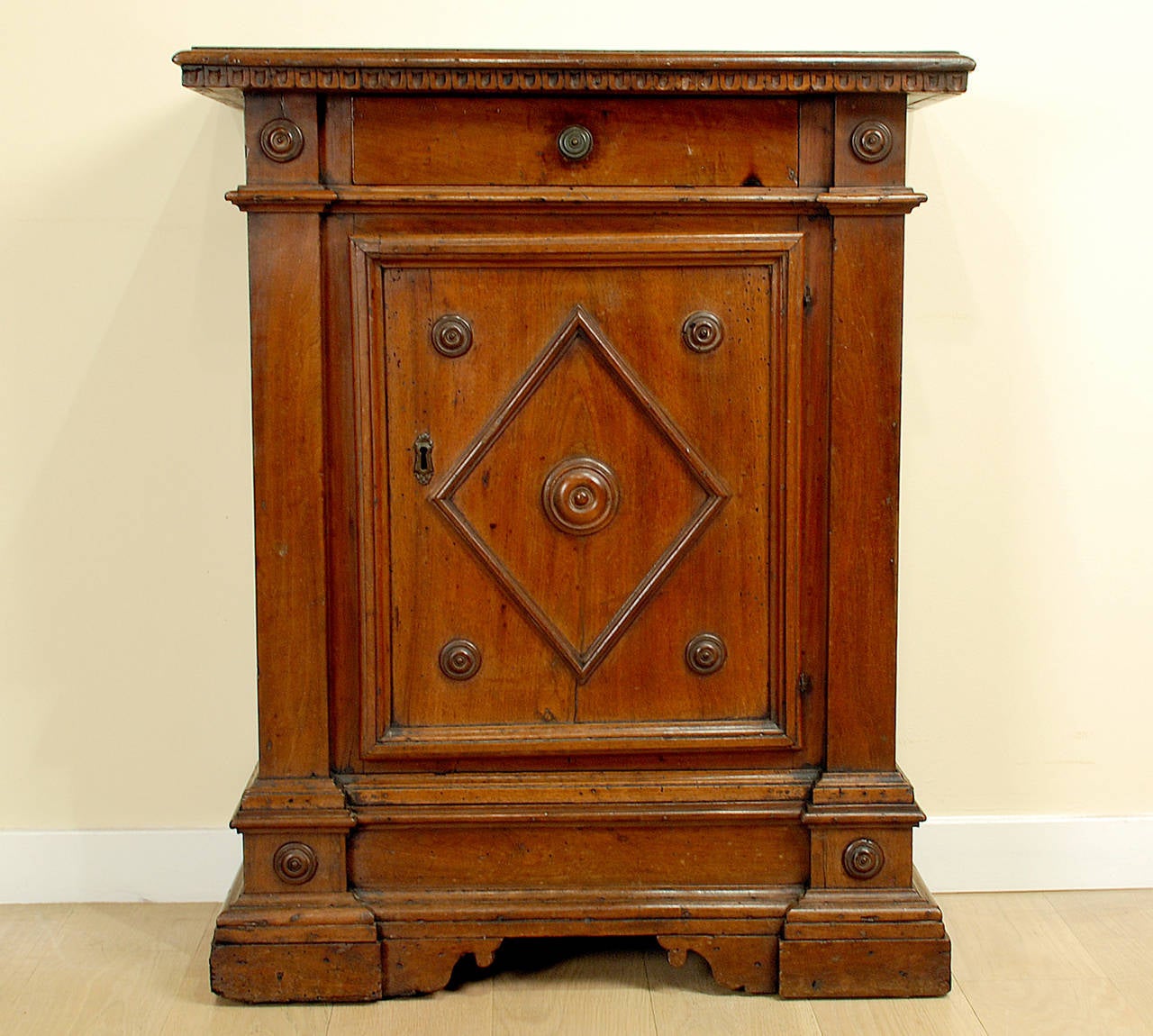 A superb 17th century Italian Baroque period walnut credenzina with single board top over a long drawer and onedoor raised on a stepped base with bracket feet. Original hardware. Beautiful honey amber color with lustrous surface patina,