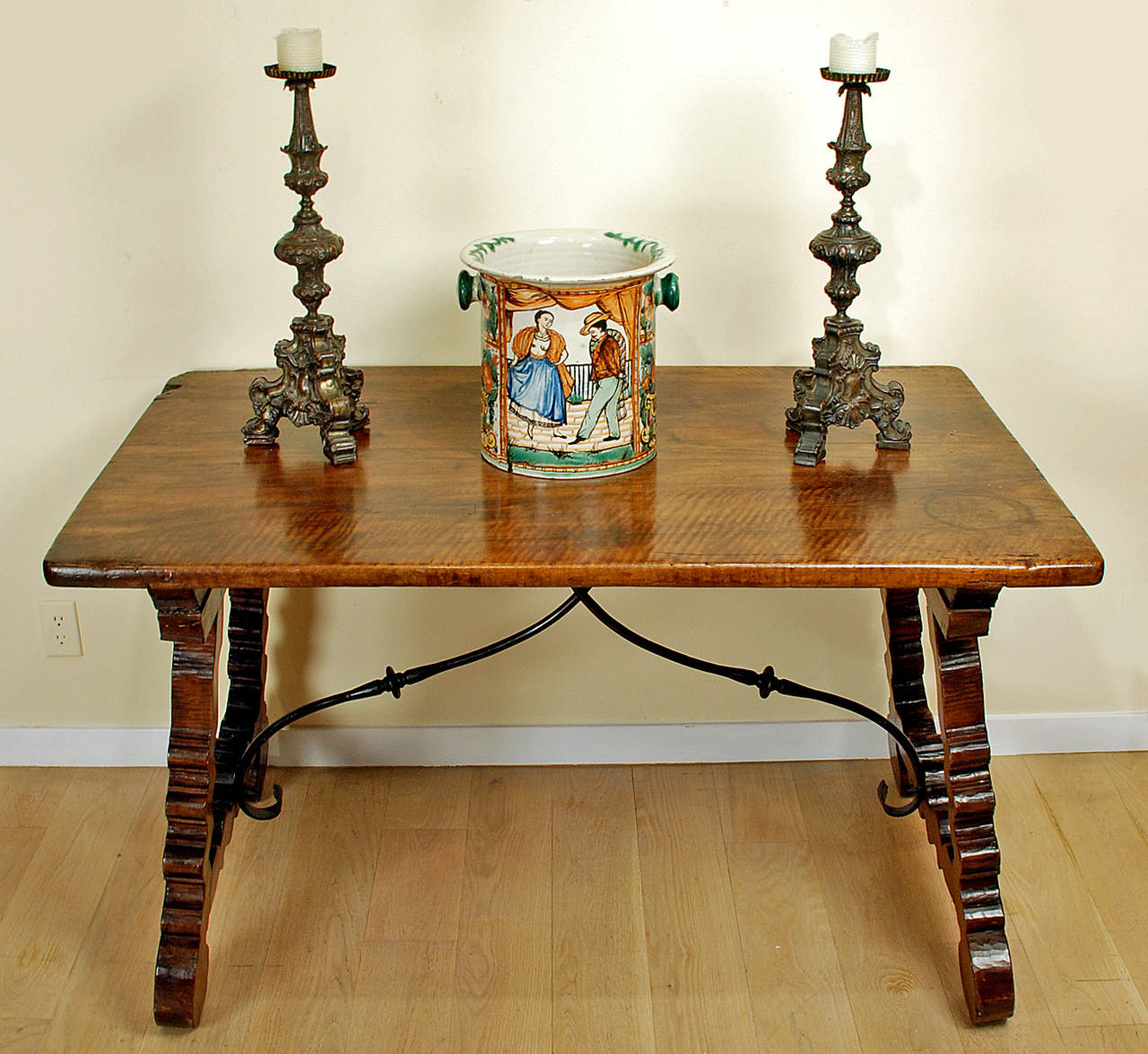 A very fine Spanish Baroque walnut center table, first half 18th century, with a thick single board rectangular top raised on scrolled trestle supports and joined by arched iron stretchers. Overall with excellent color, wear and surface