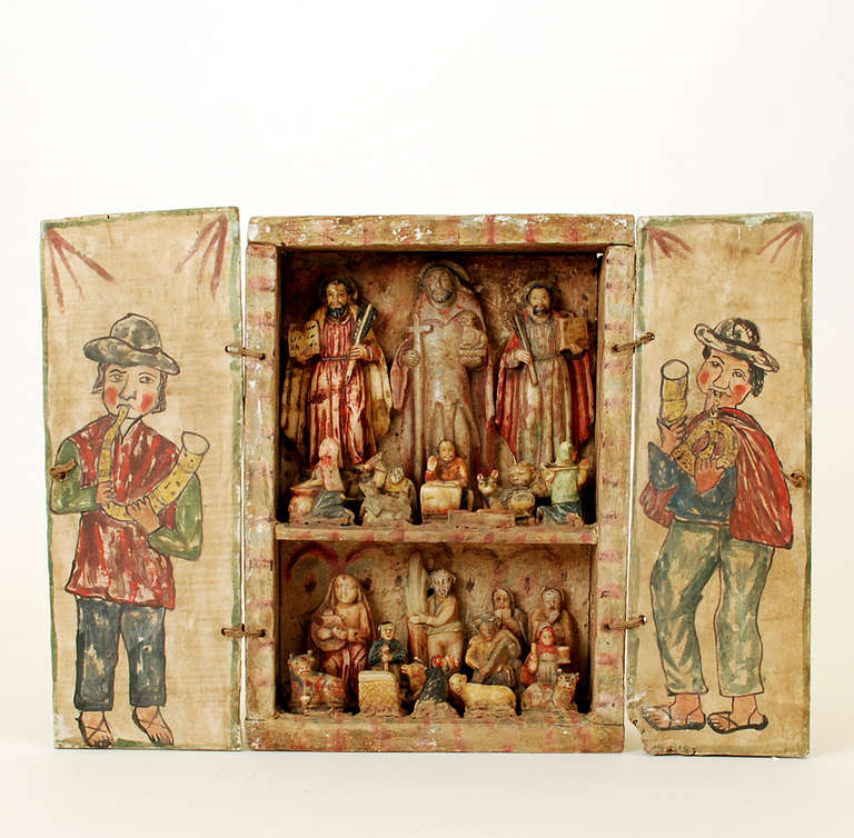A good 19th century Andean retablo box (portable shrine). The interior with various hand painted saints, animals and musicians, each carved in huamanga stone, a soft and pure form of alabaster.  

Dimensions: 16 inches wide x 12 inches high x 3