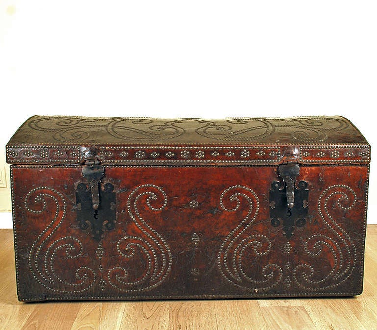 A stunning late 18th century Spanish arcon - clad in richly colored brown leather with dual lock-plates and brass studs. The interior lined in old fabric. In overall excellent, original condition with beautiful patina.

Dimensions: 48 inches long