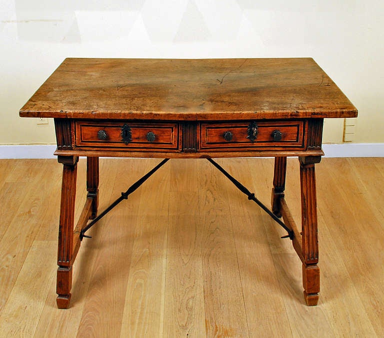 A stunning late 17th century Spanish Baroque period walnut writing desk with a single board walnut top over two inlaid drawers and splayed legs connected by a wrought iron stretcher. 

Dimensions: 43.5 inches wide x 30 inches deep x 31 inches