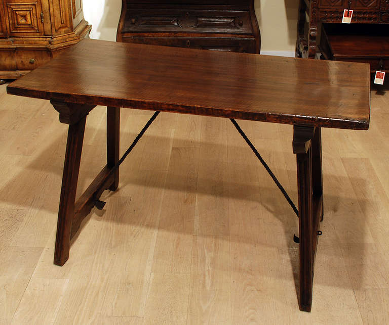 A good 18th century Spanish Baroque walnut table with a thick single board rectangular top raised on splayed legs and joined by arched iron stretchers. Overall with excellent color, wear and surface patina. 

Dimensions: 47 inches long x 23 inches