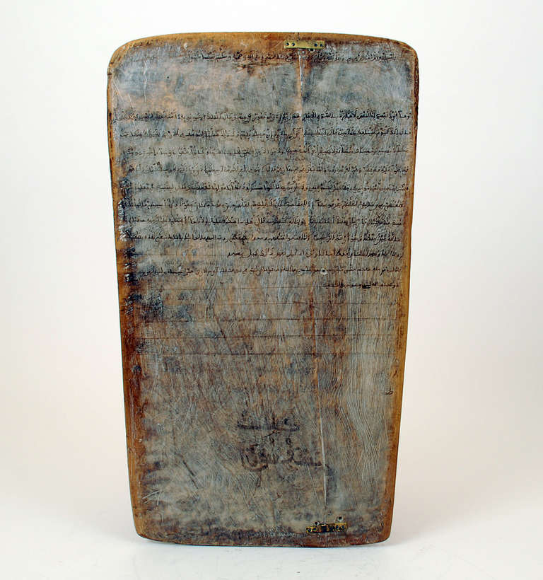 This early 20th century cedar-wood tablet (circa 1930s) is a hand painted Quranic teaching tablet from Morocco. Quranic tablets were used in Moroccan Madrasah to help students learn Quranic scripture, a teaching tool that dates back centuries, and