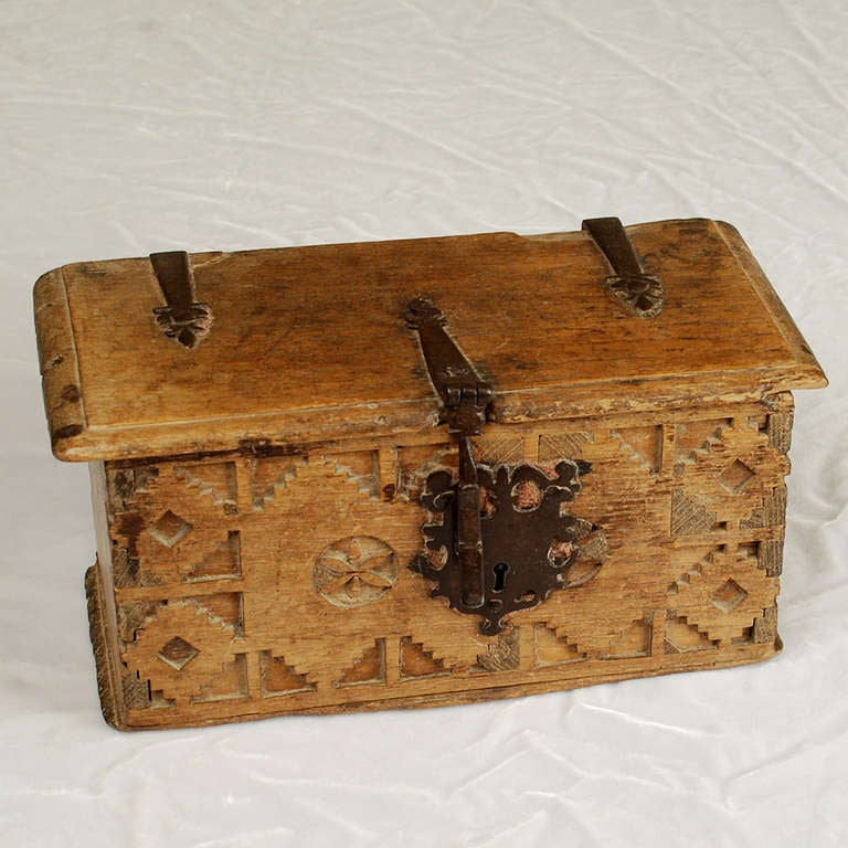 A stunning early 18th century Spanish colonial red cedar box with deeply carved geometric motifs and rosettes, together with original iron lock-plate, hasp and hinges. Iron hardware with remnants of original underlying English felt. 

Dimensions;