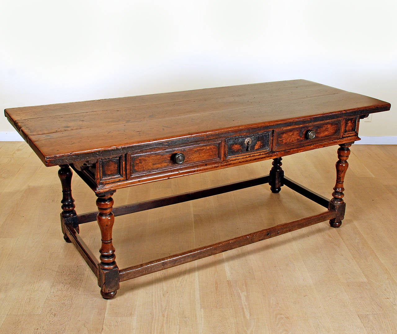 A stunning late 17th century Italian Baroque period walnut center table the thick rectangular top with battened ends over two drawers and turned legs connected by a stretcher base. Fixed center drawer flanked by two large operable drawers with