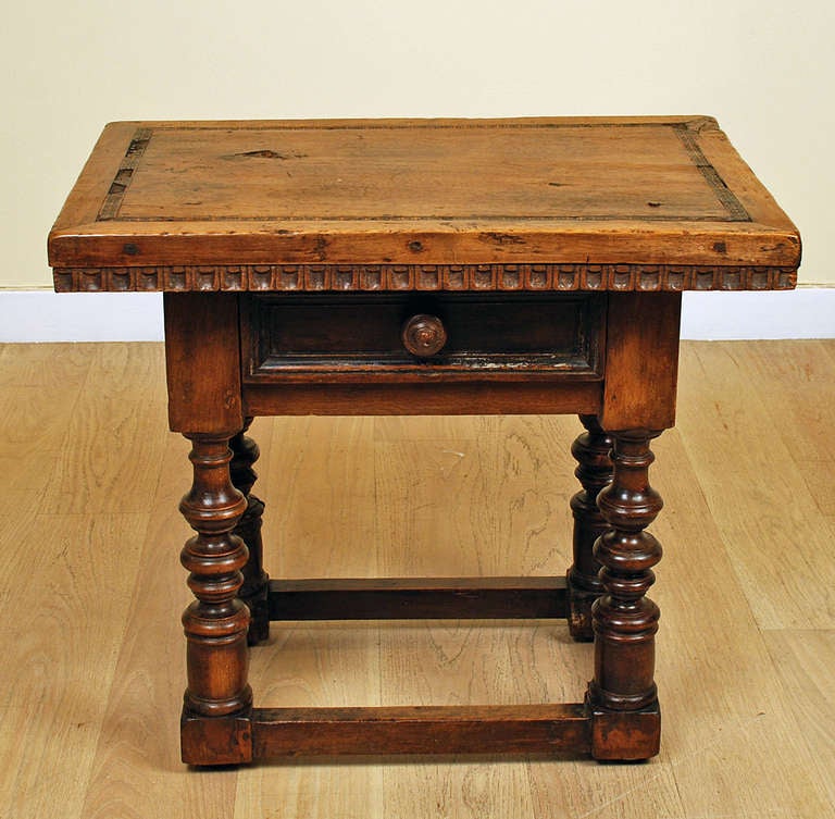 A fine and rare 17th century Italian walnut side table with a very thick single board top over a single drawer and turned legs terminating into a stretcher base. The top with inlaid geometric motifs.

Dimensions: 27.5 inches wide x 20 inches deep