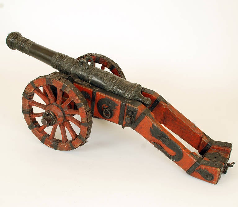 A superb 18th century German-made signal cannon with iron clad wheels and a magnificent 22 inch cast bronze barrel. Original hand painted wooden trail with original iron fittings - with excellent age tarnished patina. 

Dimensions: Overall length