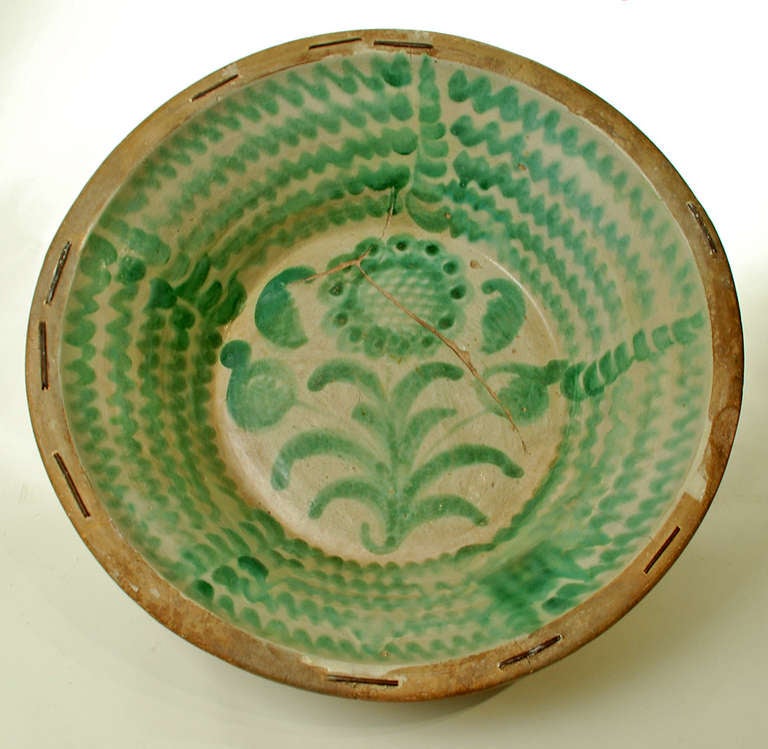 A large and impressive mid 19th century Spanish stoneware 'lebrillo' with beautiful 'morisco' green glaze over a milk white slip. This lebrillo features a large sunflower motif surrounded by whimsical foliate motifs - Granada - circa 1860. Verso