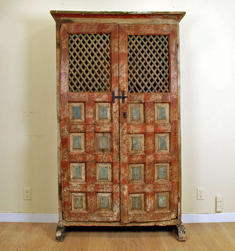 A fine early 18th century Spanish alacena (kitchen pantry) with raised panel doors, iron hardware, shoe feet, open lattice work and original hand painted surface. Interior with later shelf. 

Dimensions: 76 inches high x 45 inches wide x 15 inches