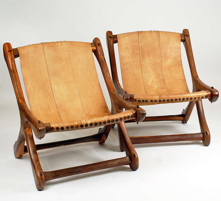 A pair of very rare mid century Don Shoemaker 'Sling Sloucher' chairs, made in rosewood with rosewood dowels, leather buttons and orignal hide sling. Original decal still affixed to underside of stretcher. Don Shoemaker, for those unfamiliar, was