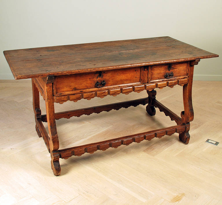 A fine and rare 18th century Mexican hacienda table with two large drawers supported by lyre shaped legs connected by a stretcher base. Oaxaca - circa 1750. 

Dimensions: 66.5 inches wide x 32.5 inches deep x 32.5 inches high.