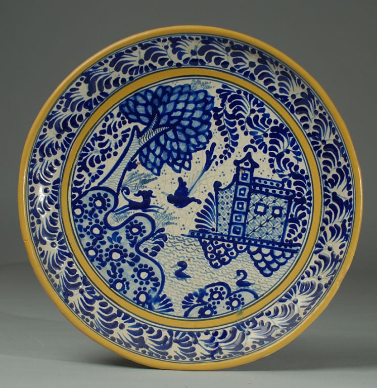 A classic, large early 20th century Mexican blue on white talavera charger with a beautifully rendered cathedral surrounded by birds, swans and trees. The underside bears the signature of Isauro Uriarte, one of Mexico's most important talavera