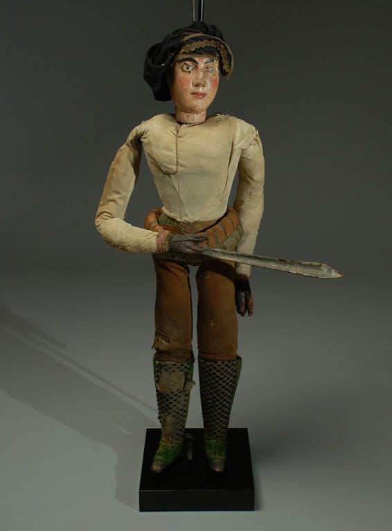 A great early 19th century Sicilian Commedia dell'arte rod puppet. Carved and polychrome painted wood with cloth wrapped extremities, hand sewn embroideries, inset glass eyes and a large heavy gauge steel suspension rod. Displayed on a high quality