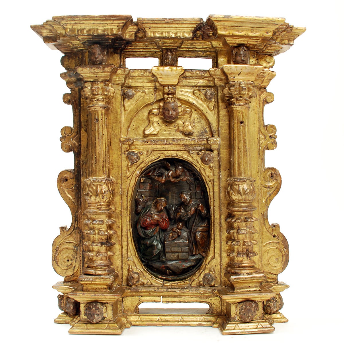 A stunning 17th century Sicilian mecca giltwood tabernacle with original hand-carved and polychrome painted nativity, flanked by a pair of columns and surmounted by cherubs and a molded frieze.

Dimensions: 20 inches vertical x 18 inches