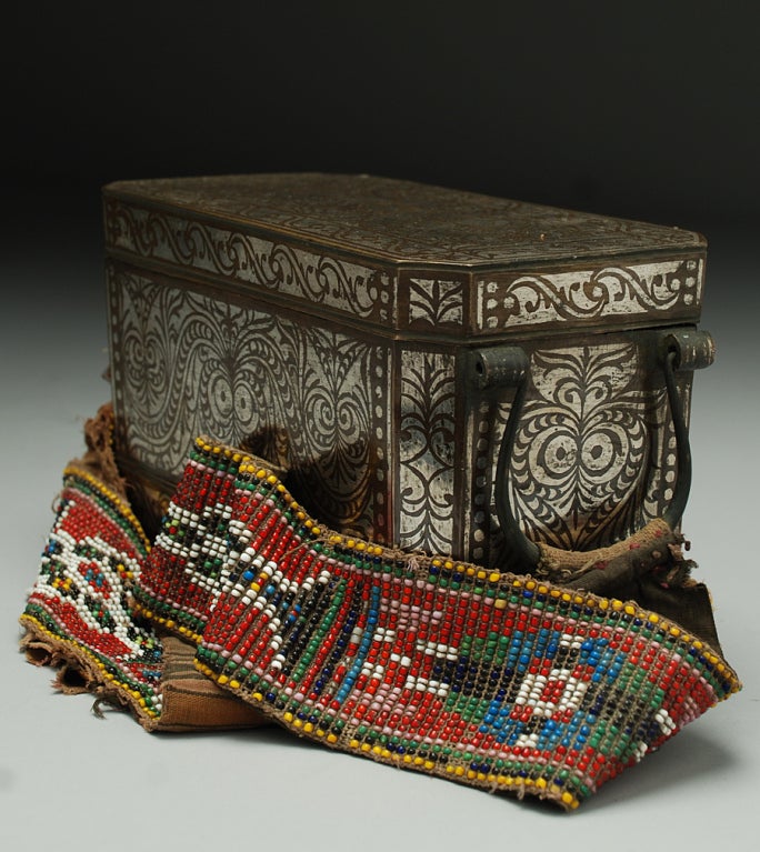 A large and impressive early 20th century silver inlaid betel nut box with removable interior compartment, wheels and original beaded strap -- from the Mindanao region in the southern Philippines. 

Betel nut boxes can still be found in the