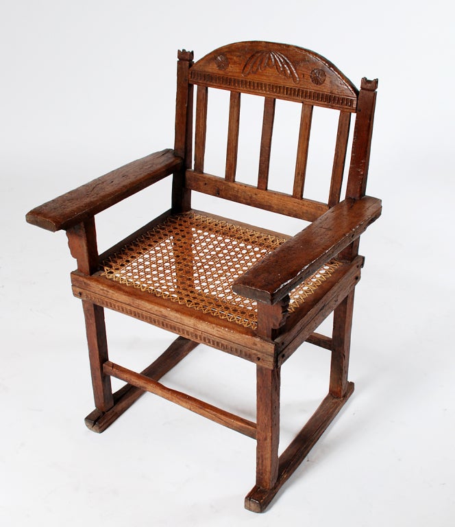 A handsome early 20th century (circa 1900 - 1910) colonial arm-chair from the Philippines. Original hand caned seat with shoe feet, wide arm rails and hand carved back-slat. Overall with beautiful wear and patina.  

Dimensions: 39 inches high x