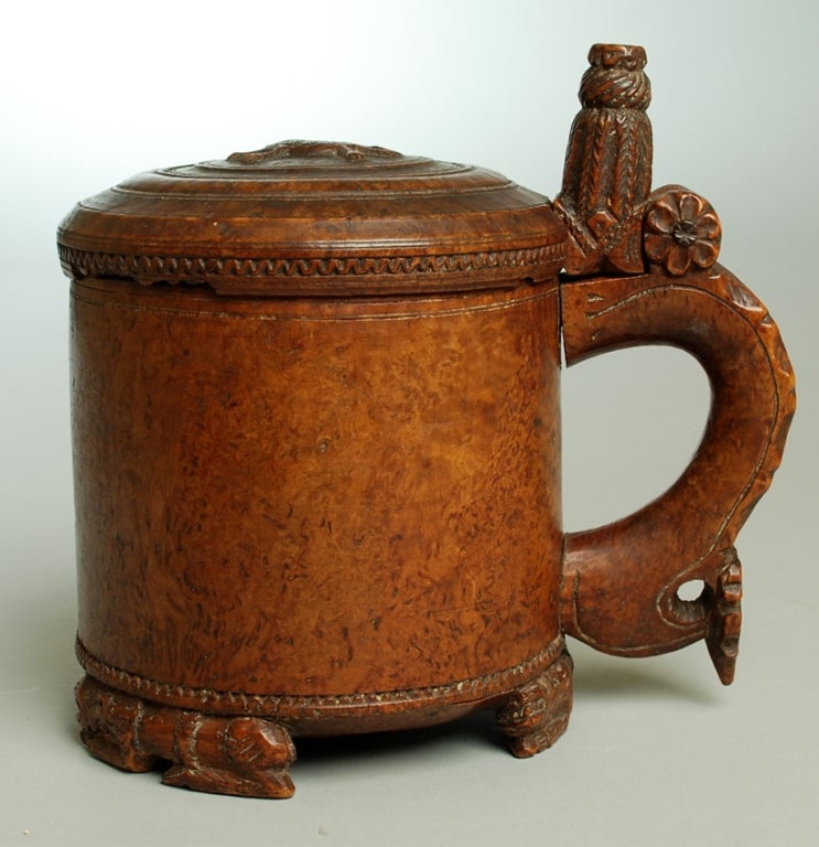 A rare 17th / 18th century Norwegian burl-wood tankard with carved handle, hinged lid, heraldic lion and footed base. Overall with excellent wear and surface patina. 

Dimensions: 8.5 inches high x 8.75 inches wide.