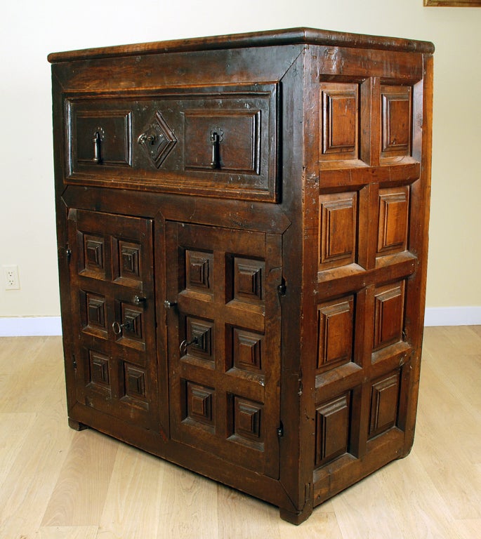 A fine 17th century Spanish walnut credenza cabinet with large raised panel drawer over two conforming doors and block feet. Original iron hardware with working lock mechanisms. Overall with rich color and beautiful patina. 

Dimensions: 39 inches