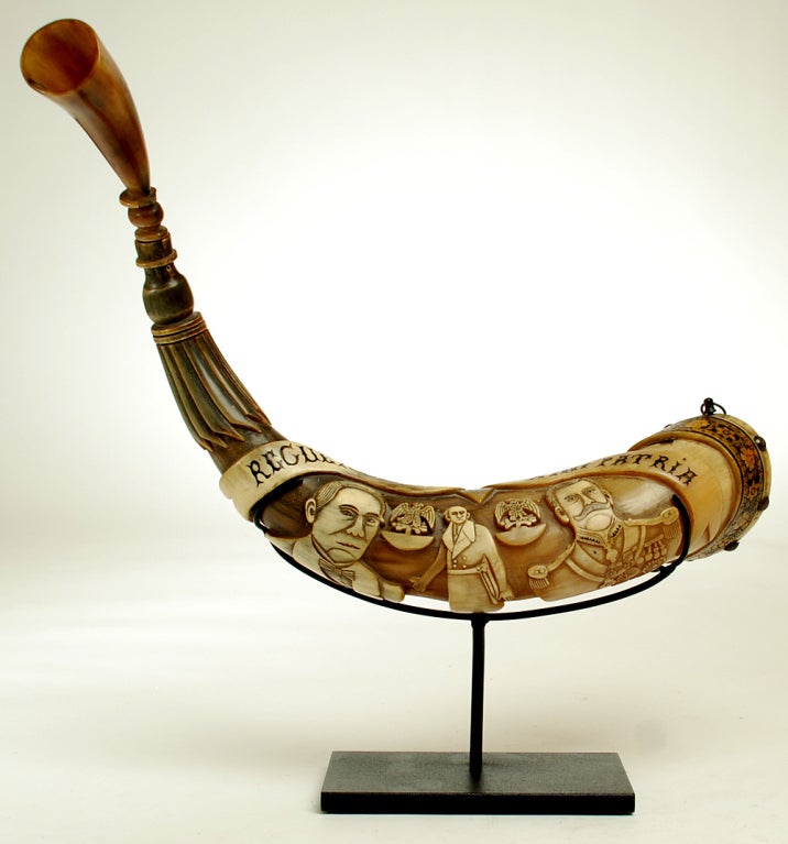This is a very large, very rare early 20th century Mexican commemorative powder horn with deep carving, inlay, brass studs and multiple inscriptions. The horn is a centennial piece, made to commemorate the 100th anniversary of Mexican Independence -